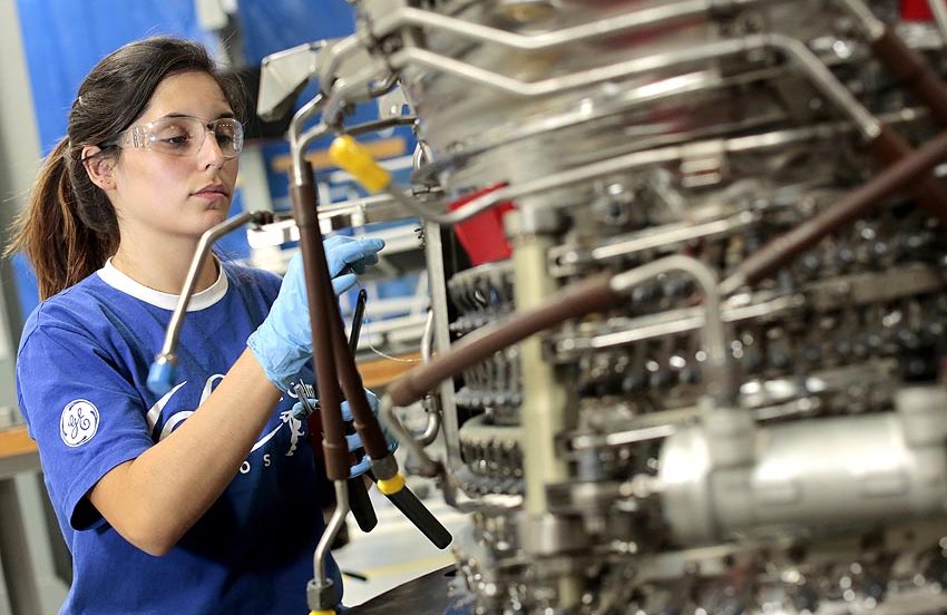 Mulher fazendo a manutenção em uma aeronave.
